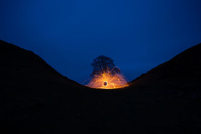 Low angle view of illuminated lights against sky at night