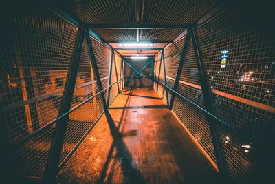 Illuminated covered footbridge in city at night