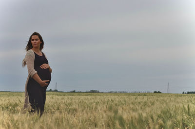 Woman standing on field against sky