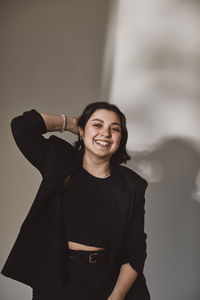 Portrait of smiling woman against white background in studio