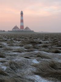 Lighthouse on beach at sunset