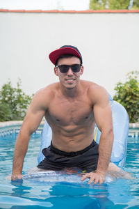 Portrait of young man swimming in pool