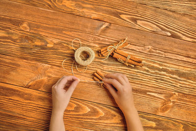 High angle view of human hand holding wooden table