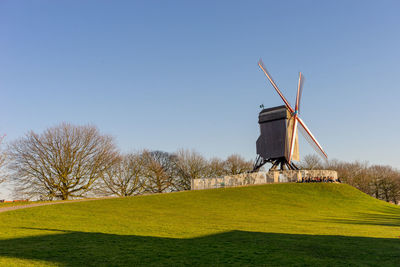 Windmill on field against clear sky