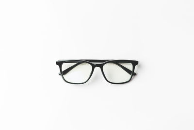 Close-up of eyeglasses on table against white background