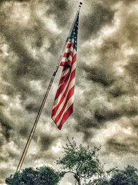 Low angle view of american flag against cloudy sky