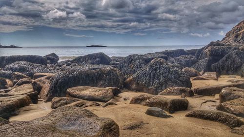 Rocks on beach against sky