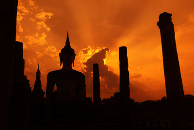 Silhouette statue against sky during sunset