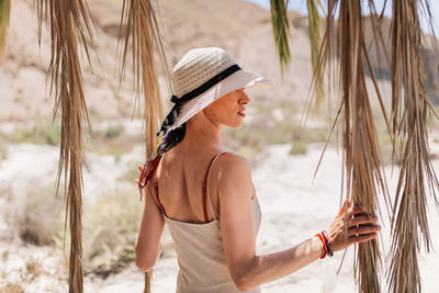 Woman wearing hat standing on beach