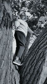 Low angle view of boy standing on tree trunk at promontory point park