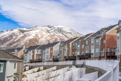 Houses against snowcapped mountains against sky