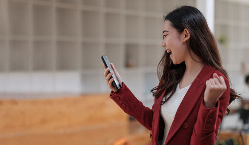 Side view of young woman using mobile phone