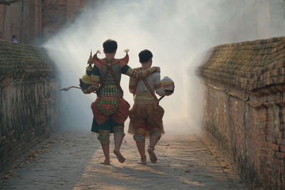 Rear view of people walking on footpath