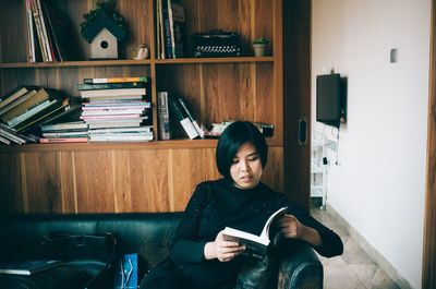 Portrait of young woman using mobile phone at home