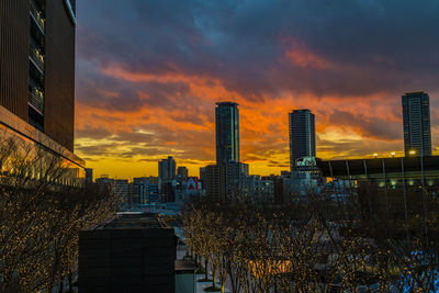 Modern buildings against sky during sunset