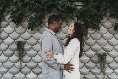 Portrait of married couple embracing and smiling at each other outside