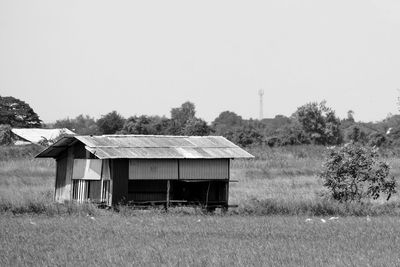 Abandoned house on field against clear sky