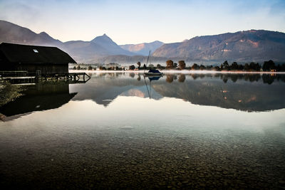 Scenic view of calm lake and mountain against sky