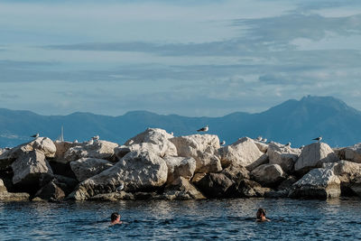 Scenic view of sea and mountains against sky