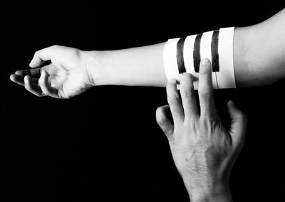 Close-up of woman hand against black background