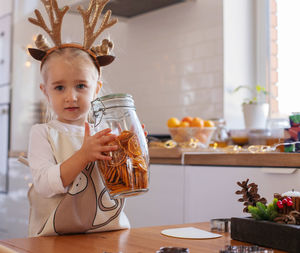 Portrait of cute girl holding good in container