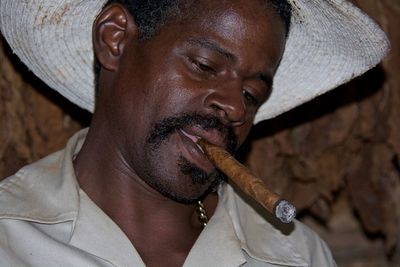 Close-up of man smoking cigar at night