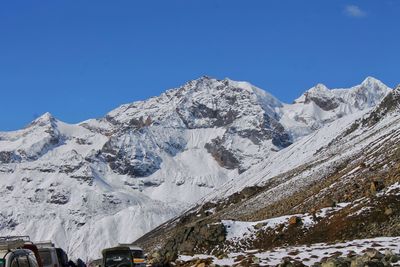 Scenic view of snowcapped mountains against clear blue sky