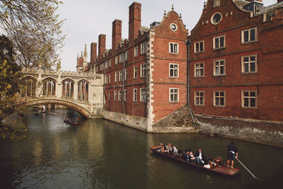 High angle view of people traveling in boat on canal amidst buildings