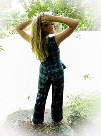 Full length of woman standing against plants