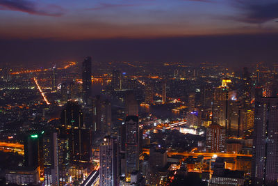 High angle view of illuminated buildings in city against sky at night