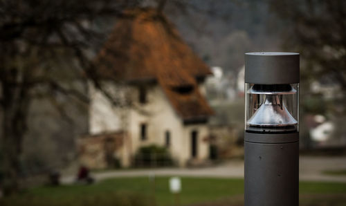 Close-up of beer glass on tree against building