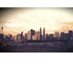 Modern buildings in city against sky during sunset