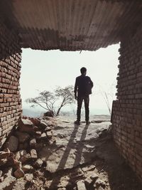 Rear view of man standing against wall