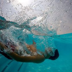 Shirtless teenage boy swimming in sea