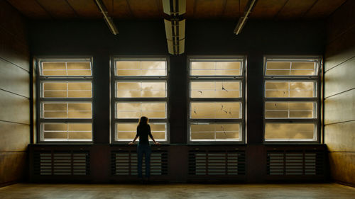 Rear view of silhouette woman standing in building