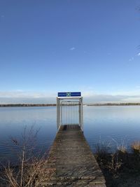 Pier over lake against blue sky