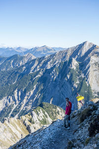 Man with umbrella on snow against mountains