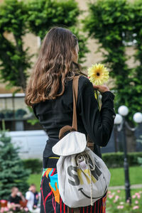 Rear view of woman standing on flower