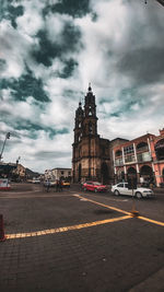 View of city buildings against cloudy sky