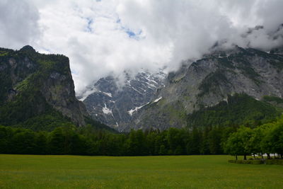 Scenic view of green landscape and mountains against sky