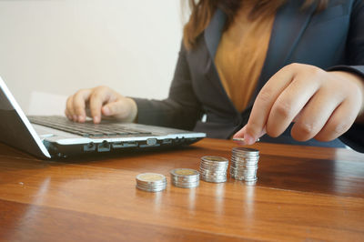 Midsection of woman using laptop on table