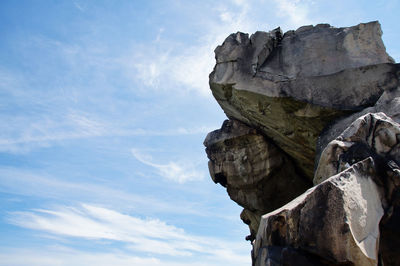 Low angle view of rock formation against sky during sunny day