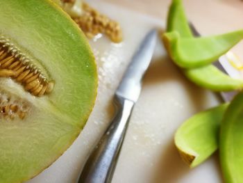 Close-up of fresh melon and knife in plate