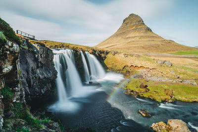 Scenic view of waterfall against sky