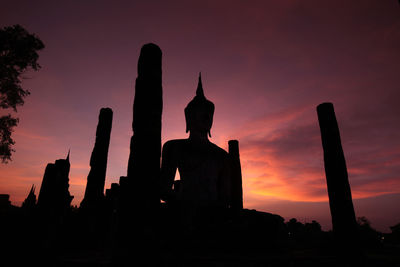 Silhouette statue against sky during sunset