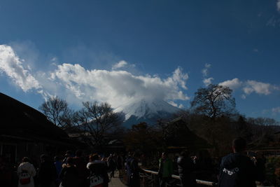 Rear view of people on mountain against sky