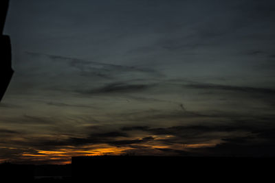 High section of silhouette built structures against scenic sky