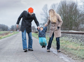 Rear view of people walking on road in winter