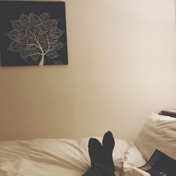 Low section of person relaxing on bed at home