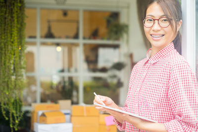 Portrait of smiling businesswoman holding clipboard